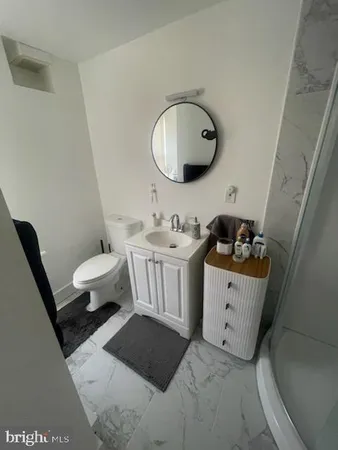 a bathroom with a sink toilet and a mirror