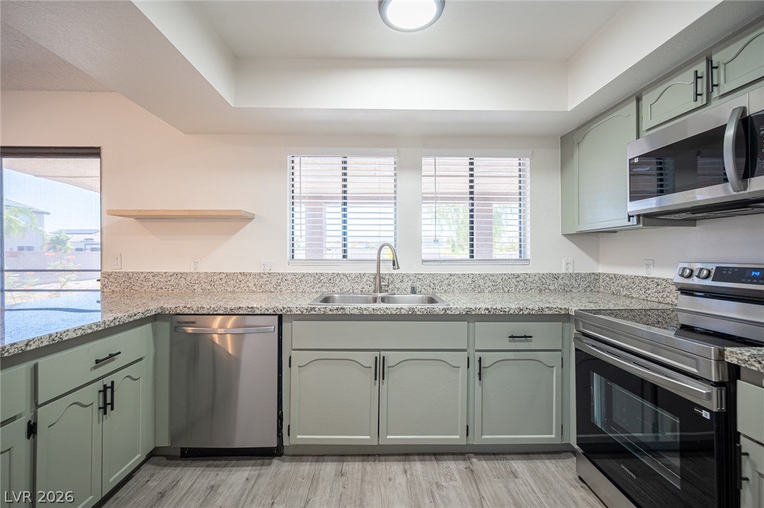 7041 North Decatur Boulevard Las Vegas, NV 89131 - Photo 7 of 33 Prepare meals in a kitchen featuring sleek granite counters and modern stainless steel appliances.
