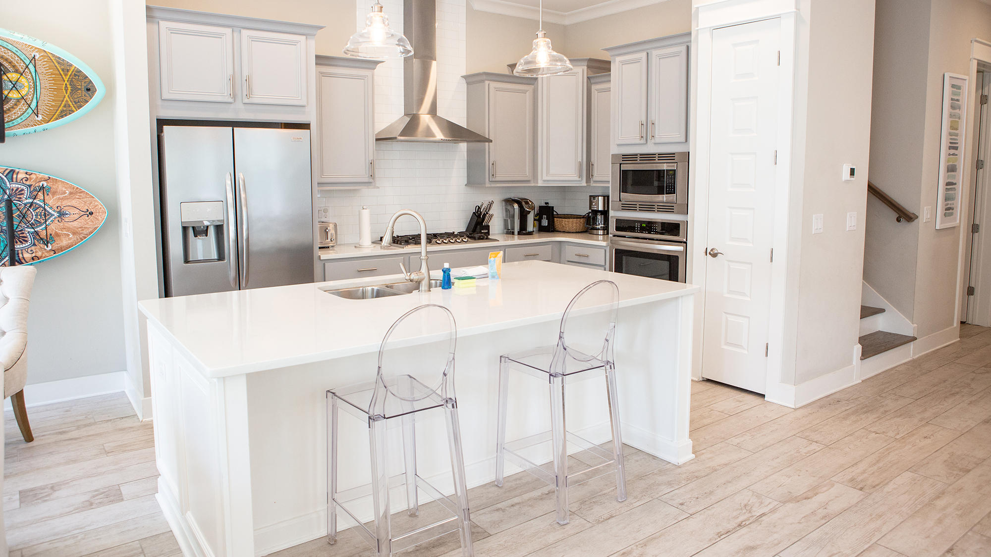 51 Dune Comet Lane, Unit A Panama City Beach, FL 32461 - Photo 2 of 63 a kitchen with stainless steel appliances a refrigerator a stove a sink and white cabinets with wooden floor