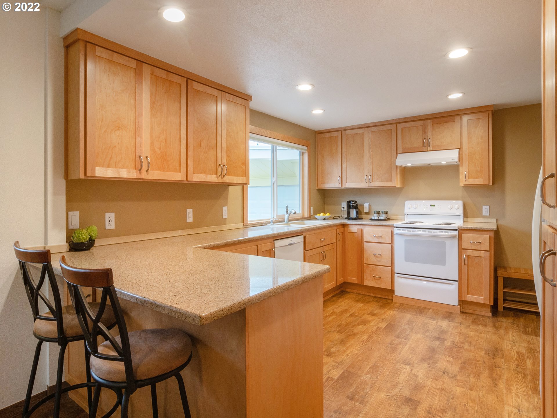 1340 E Street Springfield, OR 97477 - Photo 7 of 32 a kitchen with granite countertop a stove a sink cabinets and a refrigerator