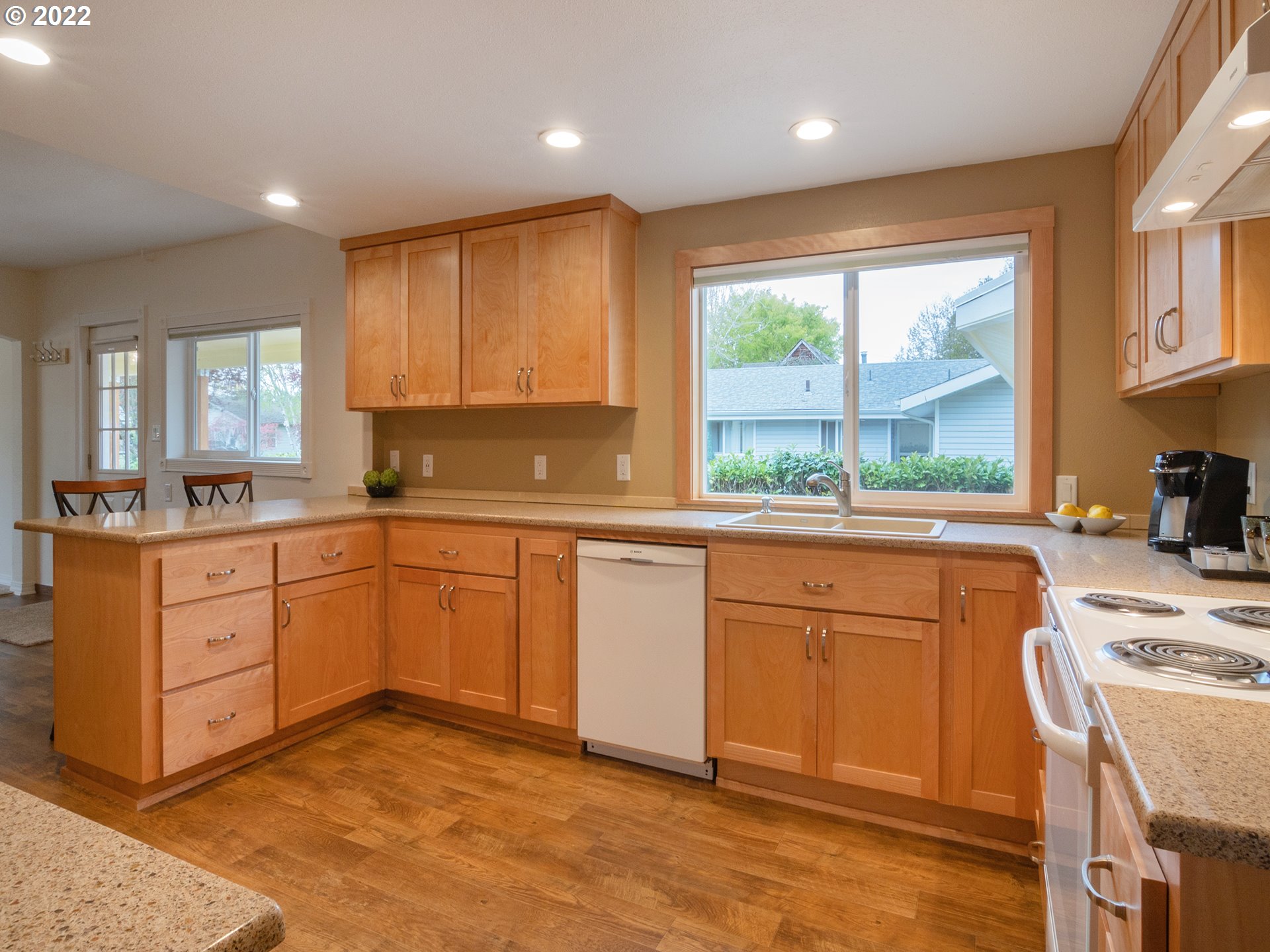 1340 E Street Springfield, OR 97477 - Photo 10 of 32 a kitchen with stainless steel appliances granite countertop a stove a sink wooden cabinets and a refrigerator