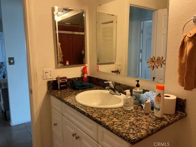 a bathroom with a granite countertop sink and a mirror