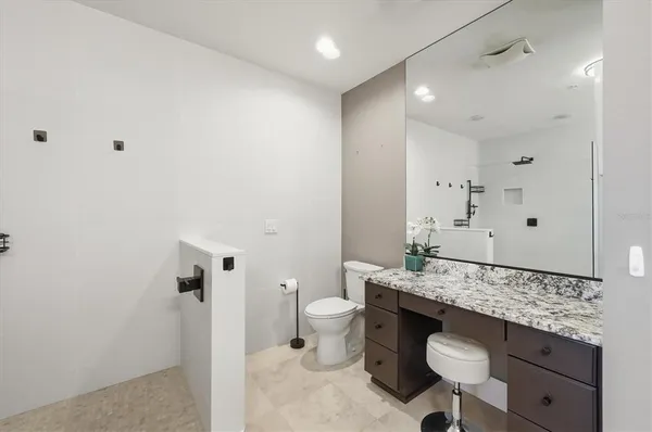 a bathroom with a granite countertop sink and a mirror
