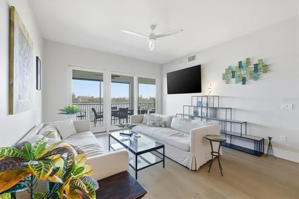 a living room with furniture and a view of kitchen
