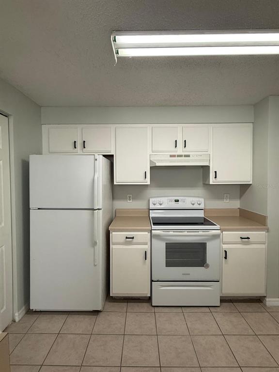 10831 Windsor Walk Drive, Unit 311 Orlando, FL 32837 - Photo 4 of 16 a white refrigerator freezer sitting inside of a kitchen