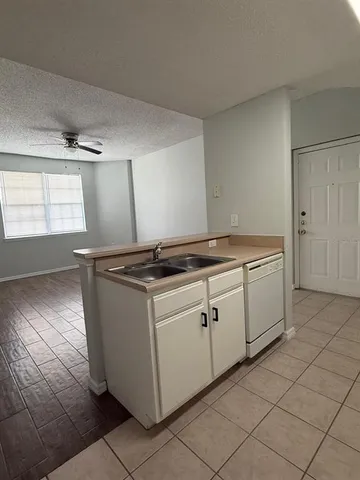 a kitchen with granite countertop white cabinets and white appliances