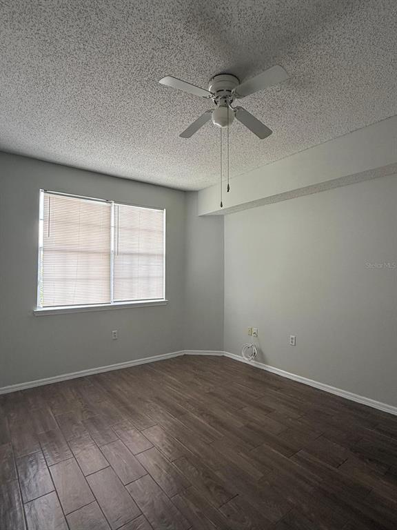 10831 Windsor Walk Drive, Unit 311 Orlando, FL 32837 - Photo 10 of 16 an empty room with wooden floor fan and windows