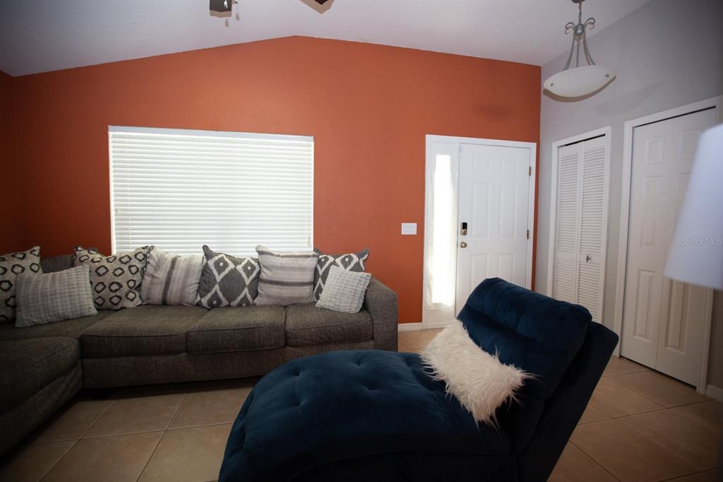 11617 Brookmore Way Riverview, FL 33569 - Photo 13 of 42 a living room with a couch and a dresser next to a window