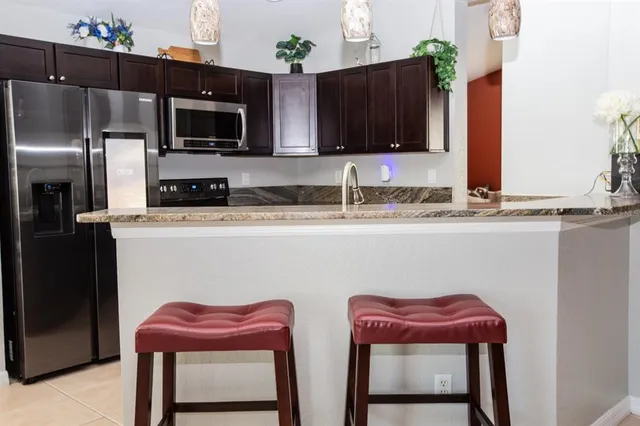 a kitchen with stainless steel appliances granite countertop a sink refrigerator and microwave