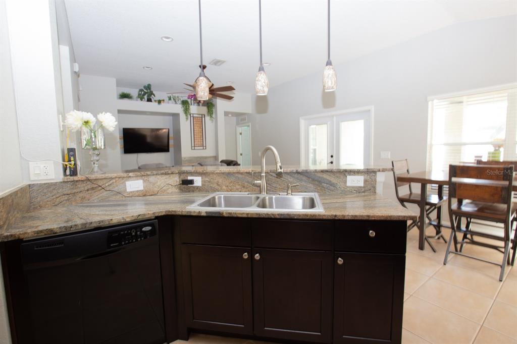 11617 Brookmore Way Riverview, FL 33569 - Photo 15 of 42 a kitchen with kitchen island granite countertop a sink and a wooden floor