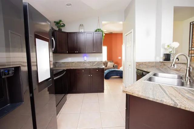a kitchen with kitchen island granite countertop a sink stove and refrigerator