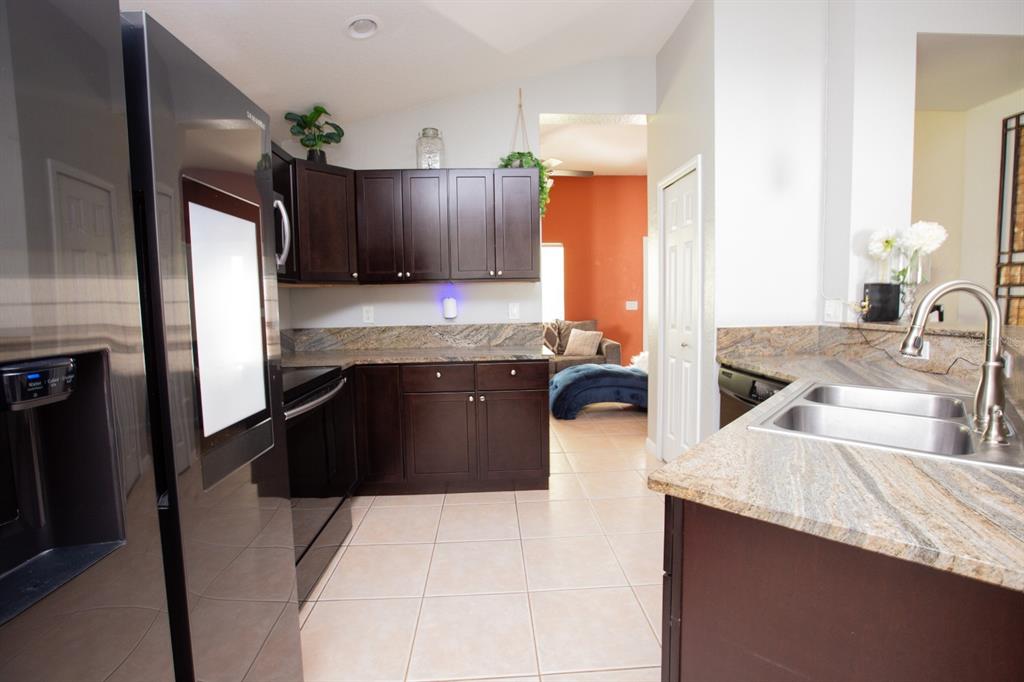 11617 Brookmore Way Riverview, FL 33569 - Photo 16 of 42 a kitchen with kitchen island granite countertop a sink stove and refrigerator