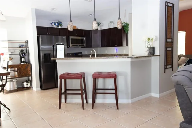 a kitchen with stainless steel appliances granite countertop a refrigerator and a stove top oven