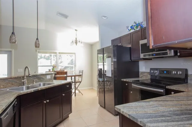 a kitchen with a sink a kitchen island and stainless steel appliances