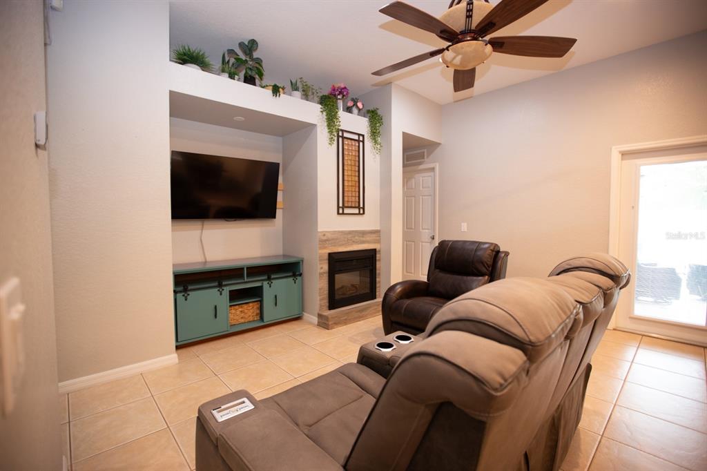 11617 Brookmore Way Riverview, FL 33569 - Photo 23 of 42 a living room with furniture a flat screen tv and a fireplace