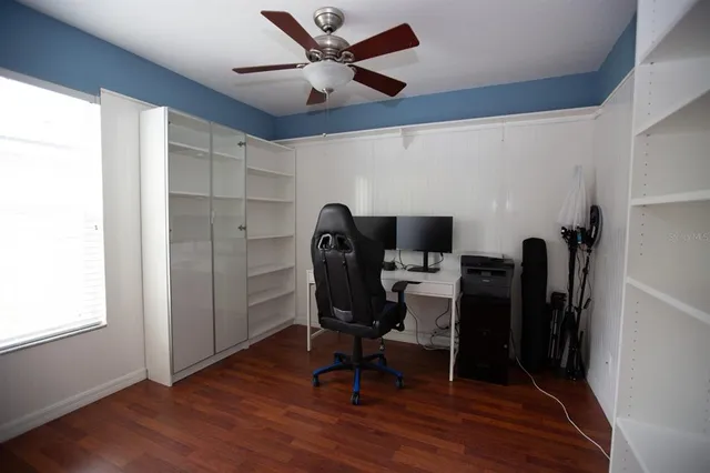 a view of a workspace with furniture and a window