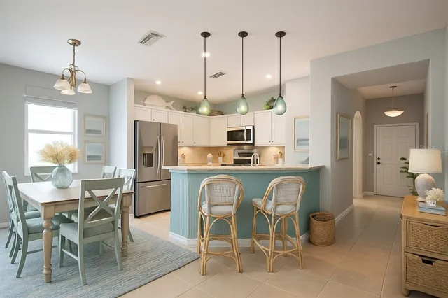 a view of a dining room and livingroom with furniture wooden floor a chandelier