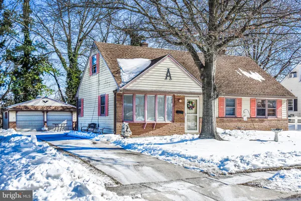 a front view of a house with a yard covered with snow