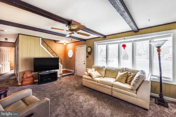 a living room with furniture a flat screen tv and a floor to ceiling window