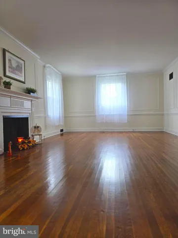 a view of a livingroom with wooden floor and a fireplace