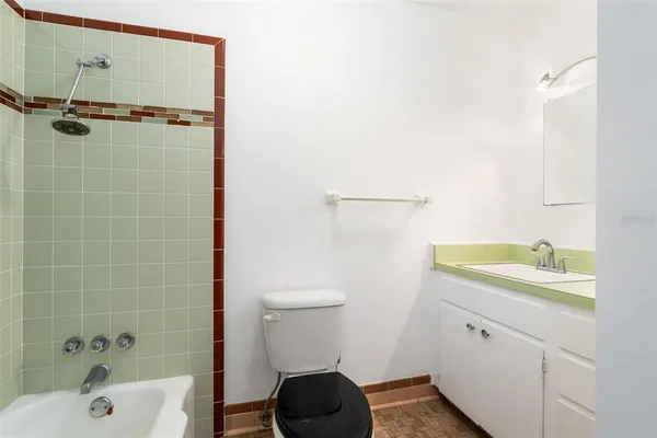a bathroom with a granite countertop sink a toilet and shower