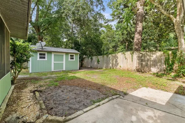 a view of a house with backyard and trees
