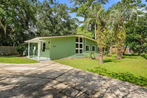 a front view of a house with yard and green space