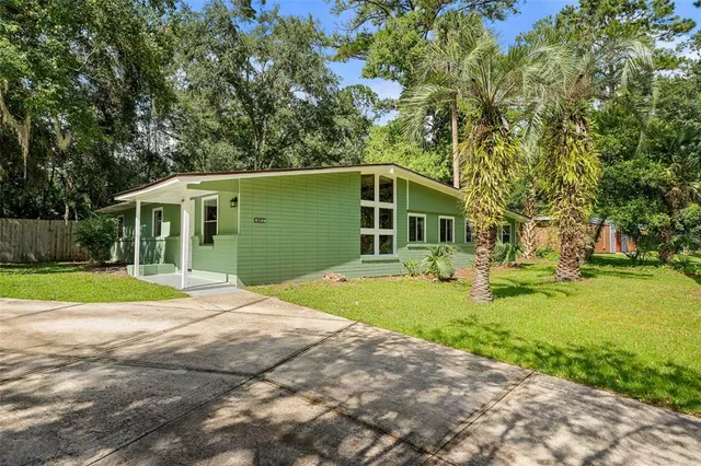 a front view of a house with yard and green space