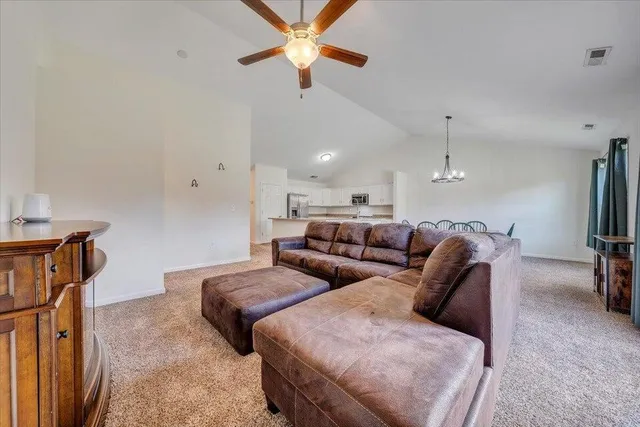 a living room with furniture a ceiling fan and a rug