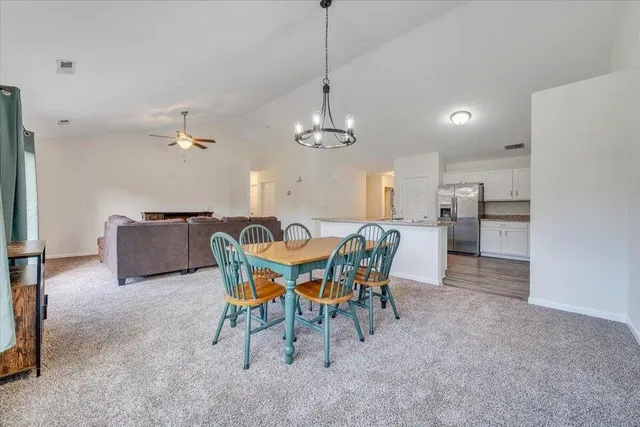 a view of a dining room with furniture and chandelier