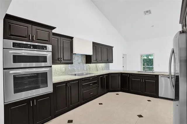 a kitchen with stainless steel appliances granite countertop a sink stove and refrigerator