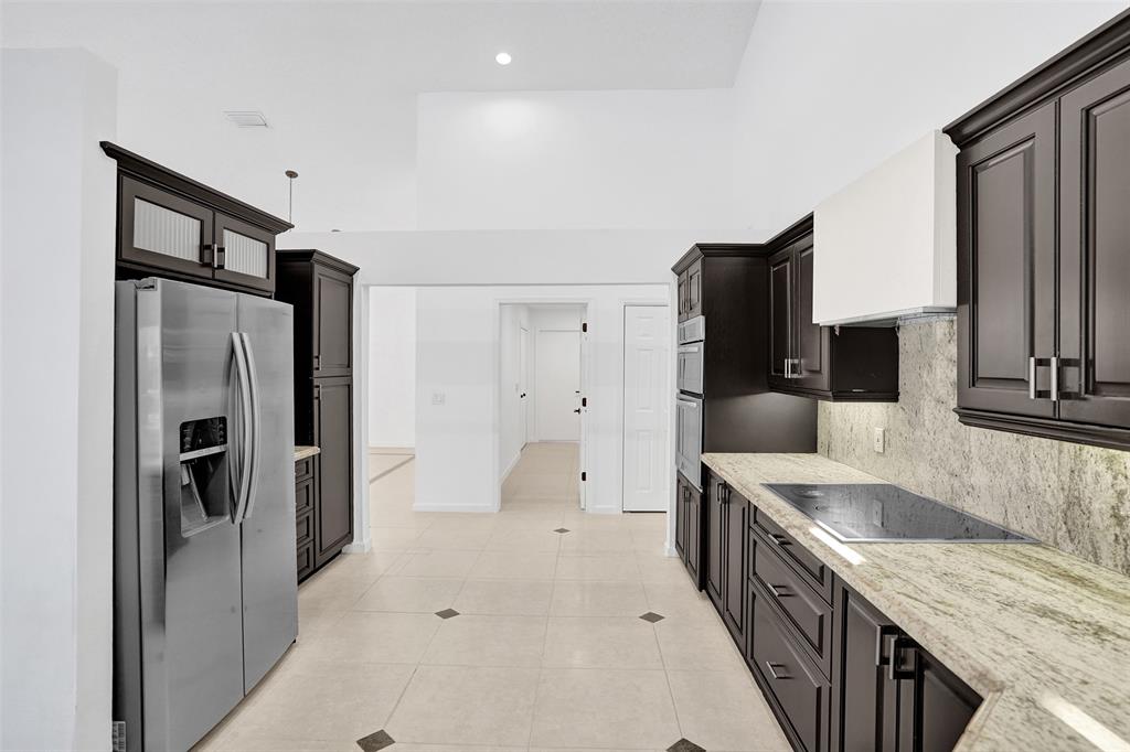 2891 Northwest 28th Terrace Boca Raton, FL 33434 - Photo 15 of 51 a kitchen with stainless steel appliances granite countertop a refrigerator a stove and a sink
