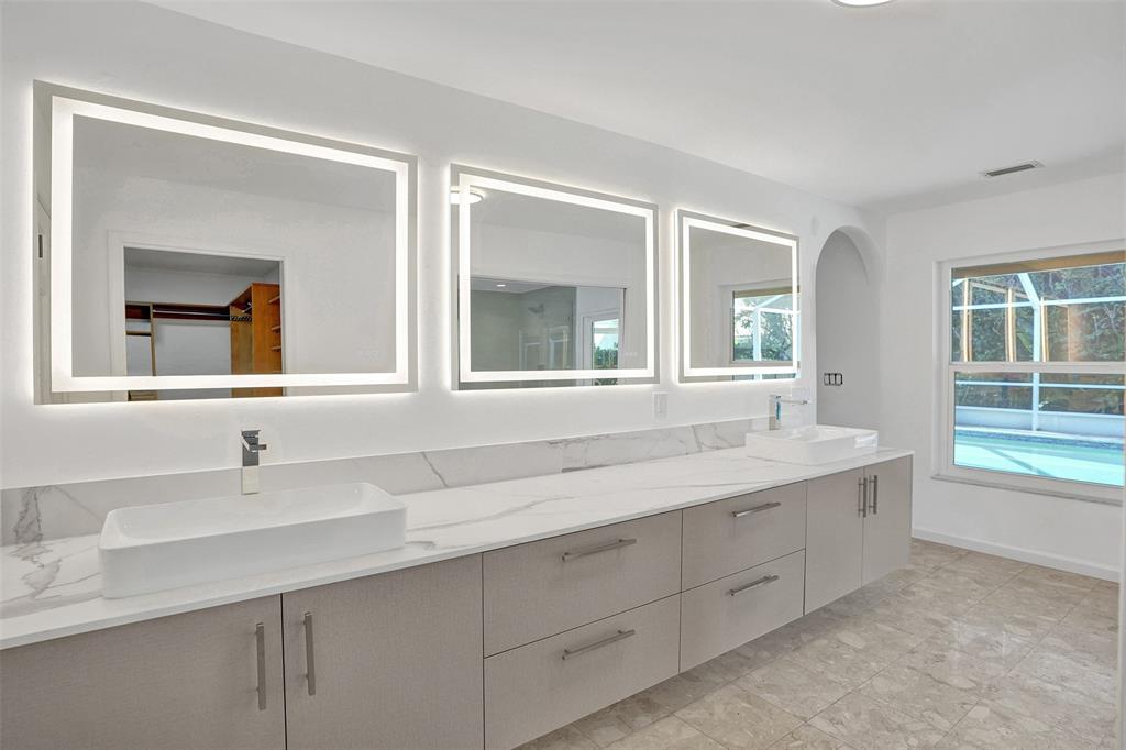 2891 Northwest 28th Terrace Boca Raton, FL 33434 - Photo 30 of 51 a bathroom with double vanity sink a two mirror a window and a