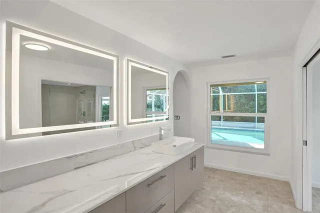 a spacious bathroom with a tub sink and mirror