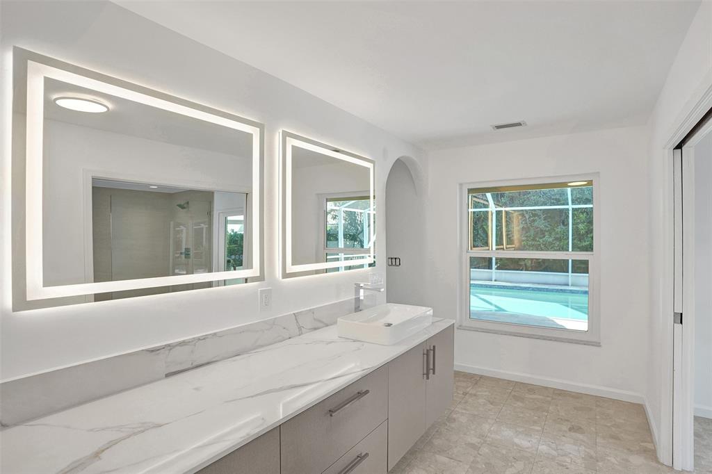 2891 Northwest 28th Terrace Boca Raton, FL 33434 - Photo 31 of 51 a bathroom with a sink mirror and a bathtub