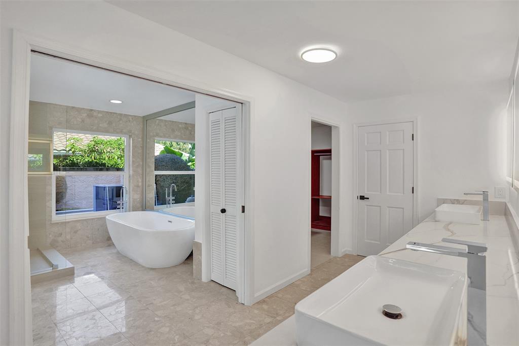 2891 Northwest 28th Terrace Boca Raton, FL 33434 - Photo 33 of 51 a spacious bathroom with a tub sink and mirror