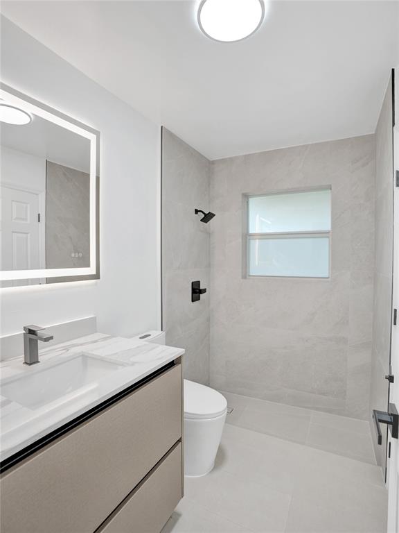 2891 Northwest 28th Terrace Boca Raton, FL 33434 - Photo 43 of 51 a bathroom with a granite countertop sink a toilet and a mirror