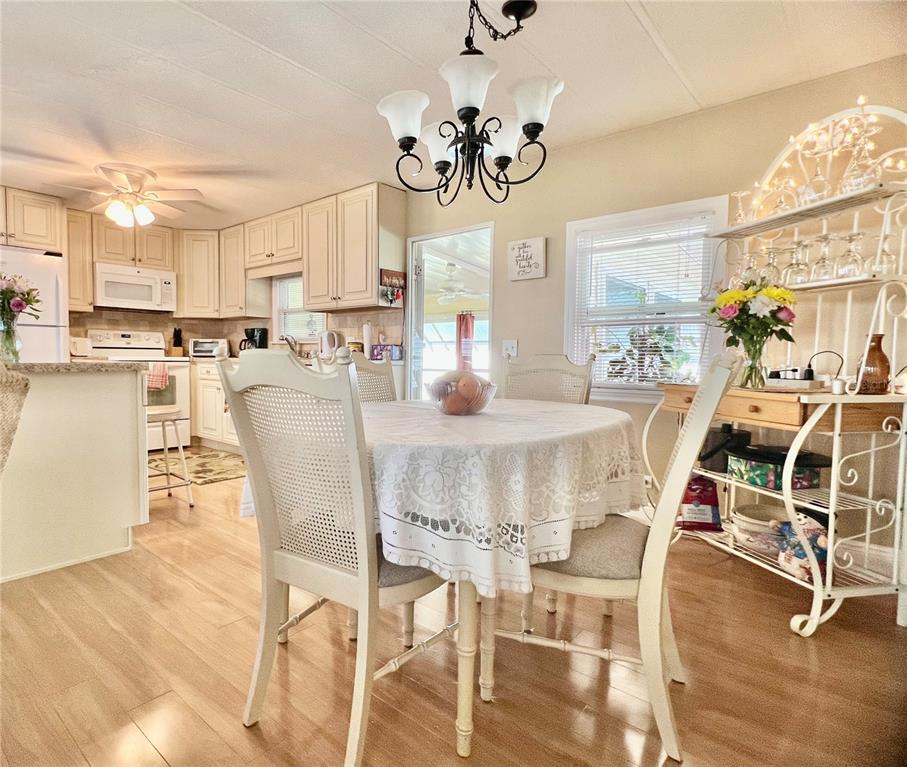 1100 South Belcher Road, Unit 113 Largo, FL 33771 - Photo 22 of 66 a view of a dining room with furniture a chandelier and wooden floor