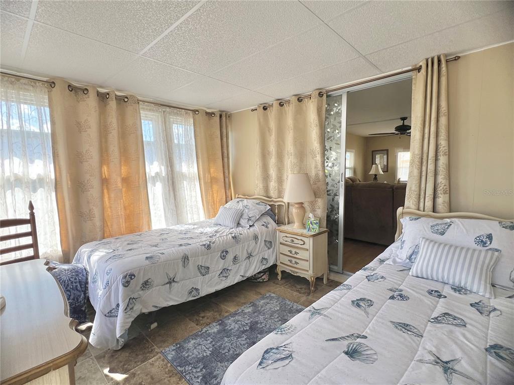 1100 South Belcher Road, Unit 113 Largo, FL 33771 - Photo 25 of 66 a bedroom with bed and large window with chair