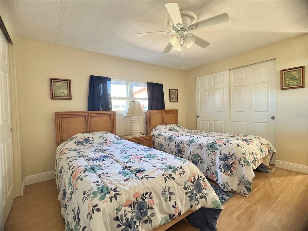 1100 South Belcher Road, Unit 113 Largo, FL 33771 - Photo 27 of 66 a bedroom with two beds and a chandelier