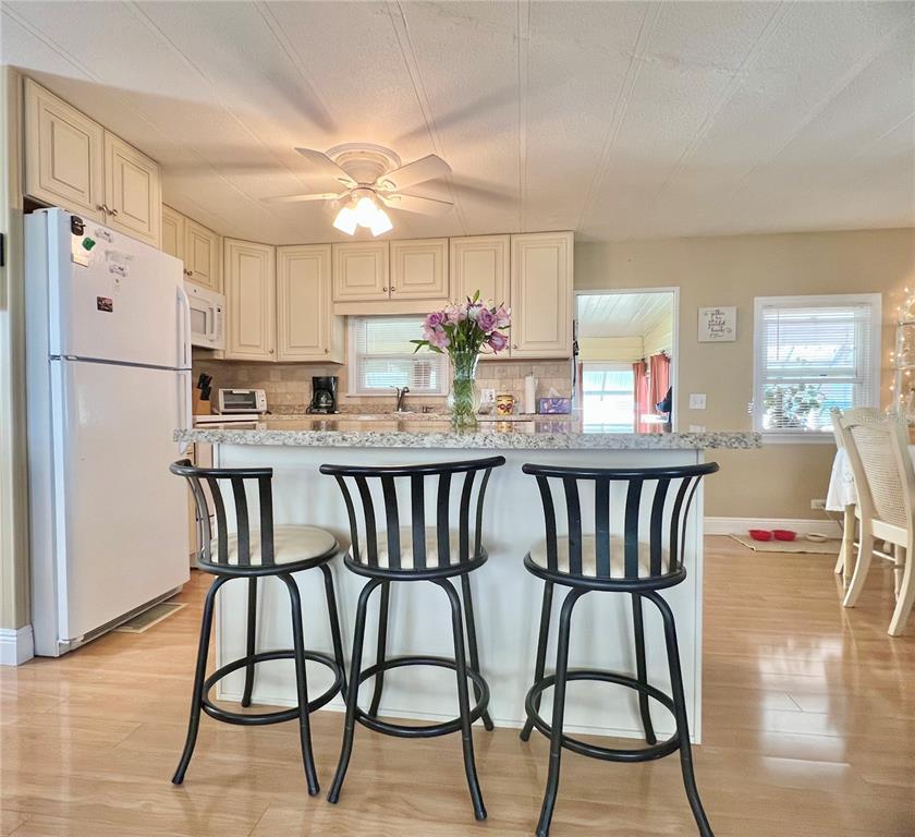 1100 South Belcher Road, Unit 113 Largo, FL 33771 - Photo 32 of 66 a kitchen with stainless steel appliances granite countertop a dining table chairs refrigerator and sink