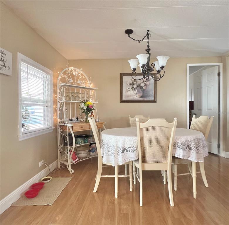 1100 South Belcher Road, Unit 113 Largo, FL 33771 - Photo 34 of 66 a dining room with furniture a chandelier and wooden floor