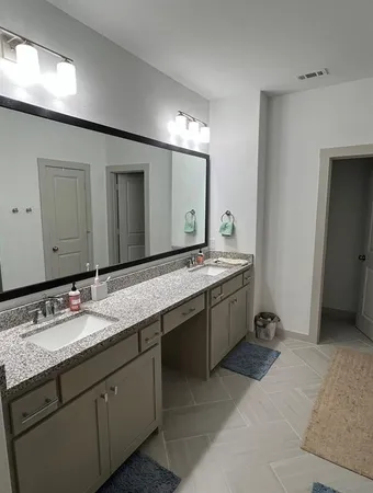 a bathroom with a granite countertop sink double and mirror