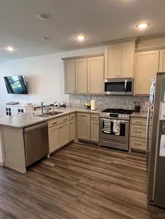 a kitchen with stainless steel appliances granite countertop a stove a sink and a refrigerator