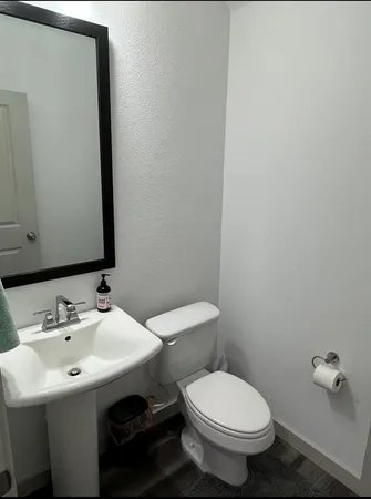 a bathroom with a sink toilet and mirror