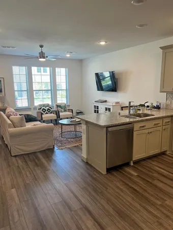 a living room with stainless steel appliances kitchen island granite countertop a sink and cabinets