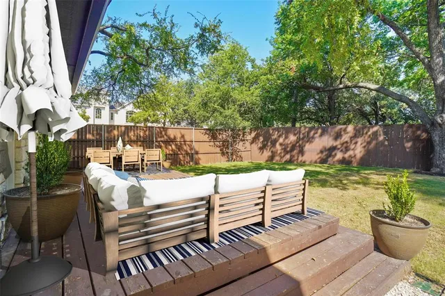a view of a patio with wooden chairs and a table