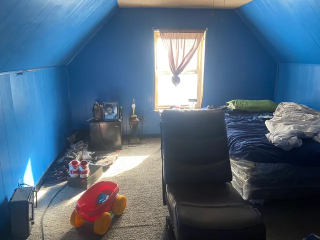 a bed sitting in a bedroom next to a window
