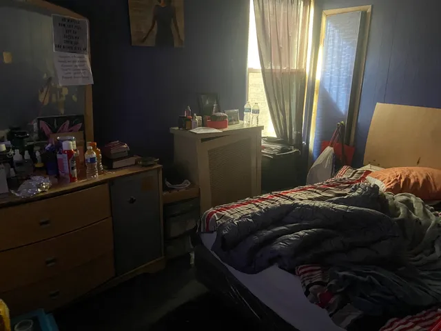 a bed sitting in a bedroom next to a window