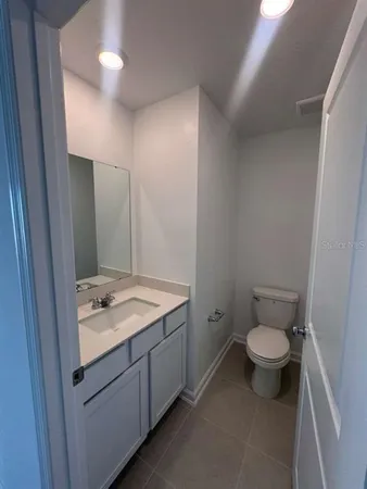 a bathroom with a granite countertop sink a toilet and a mirror